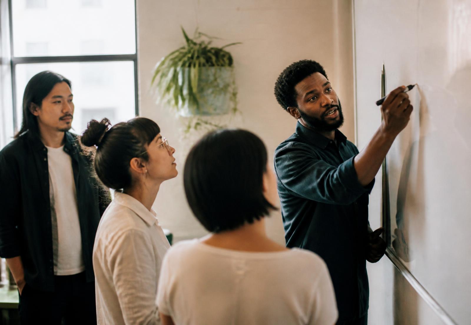 A team collaborating around a whiteboard during a training session